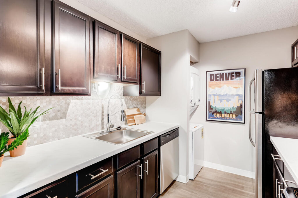 Upscale kitchen with dark cabinets and stainless steel appliances at Sage at Panorama apartments in Denver, CO
