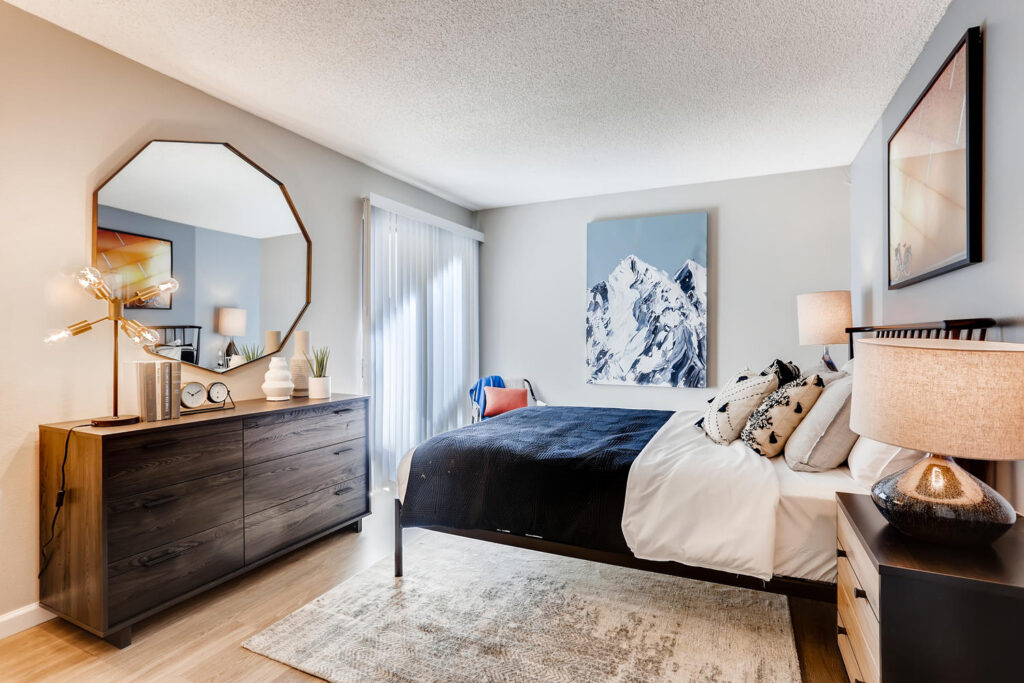 Bedroom with modern decor at Sage at Panorama apartment complex in Denver, CO