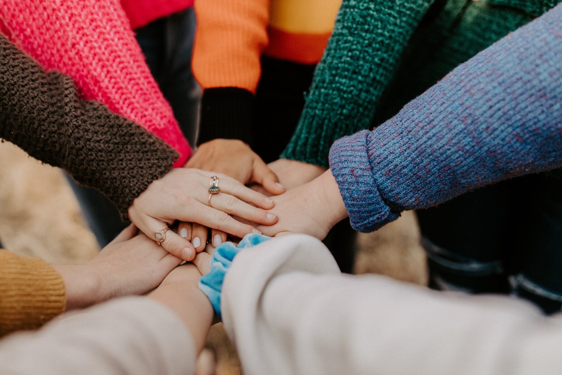 diverse hands together in a circle